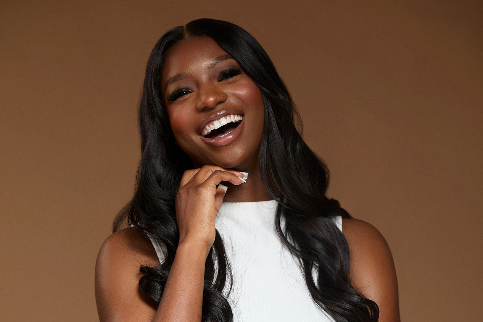Al'leesha Hamilton laughing against a warm brown background