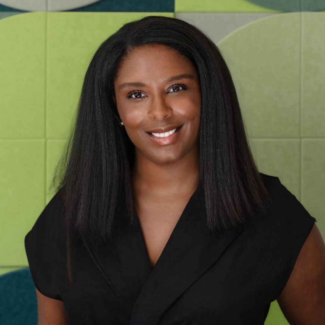 Nhela Vehar, bookkeeper and CEO, smiling in a black top